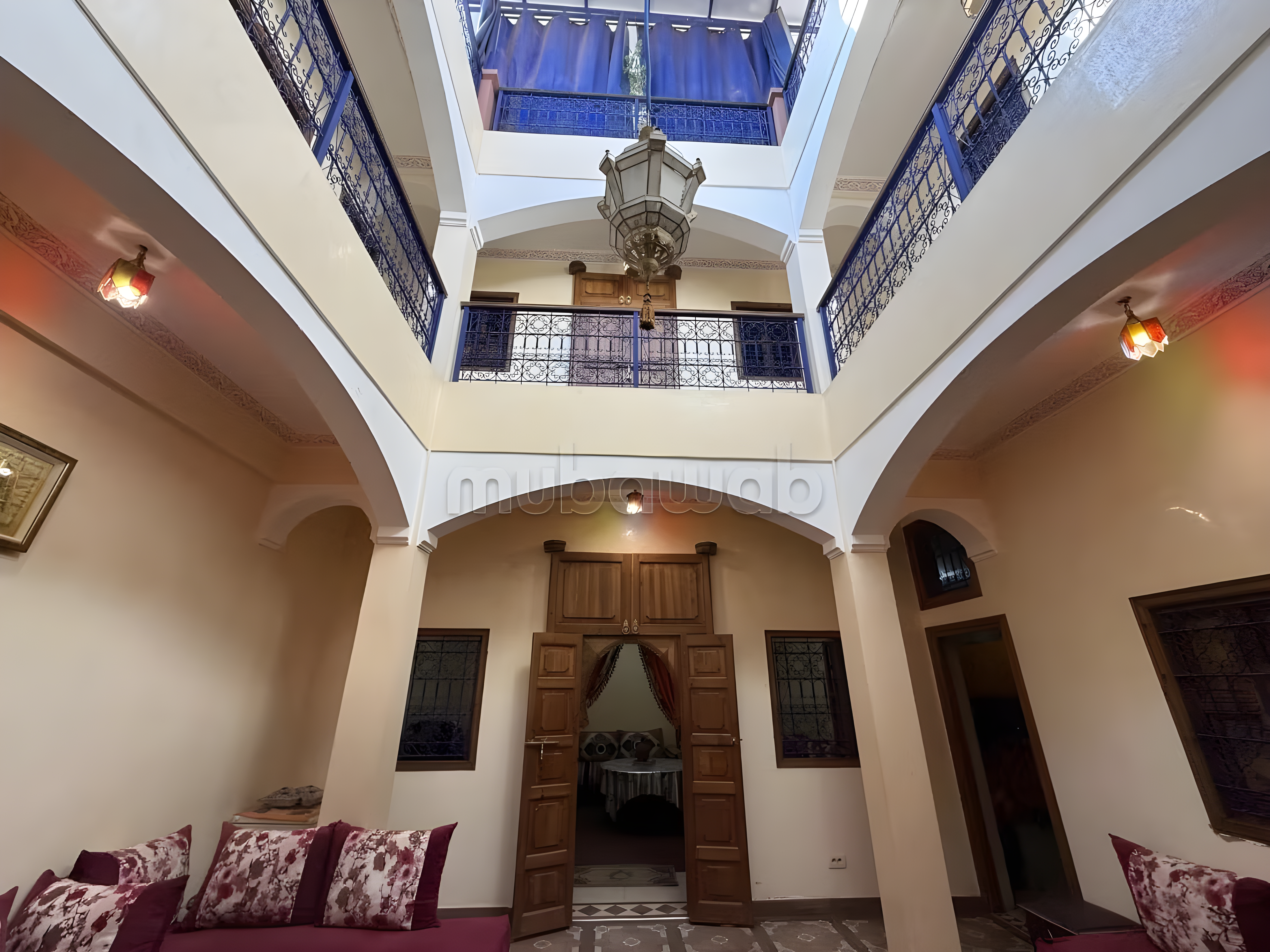 Traditional Moroccan courtyard in Sidi Mimoun with balconies and ironwork.
