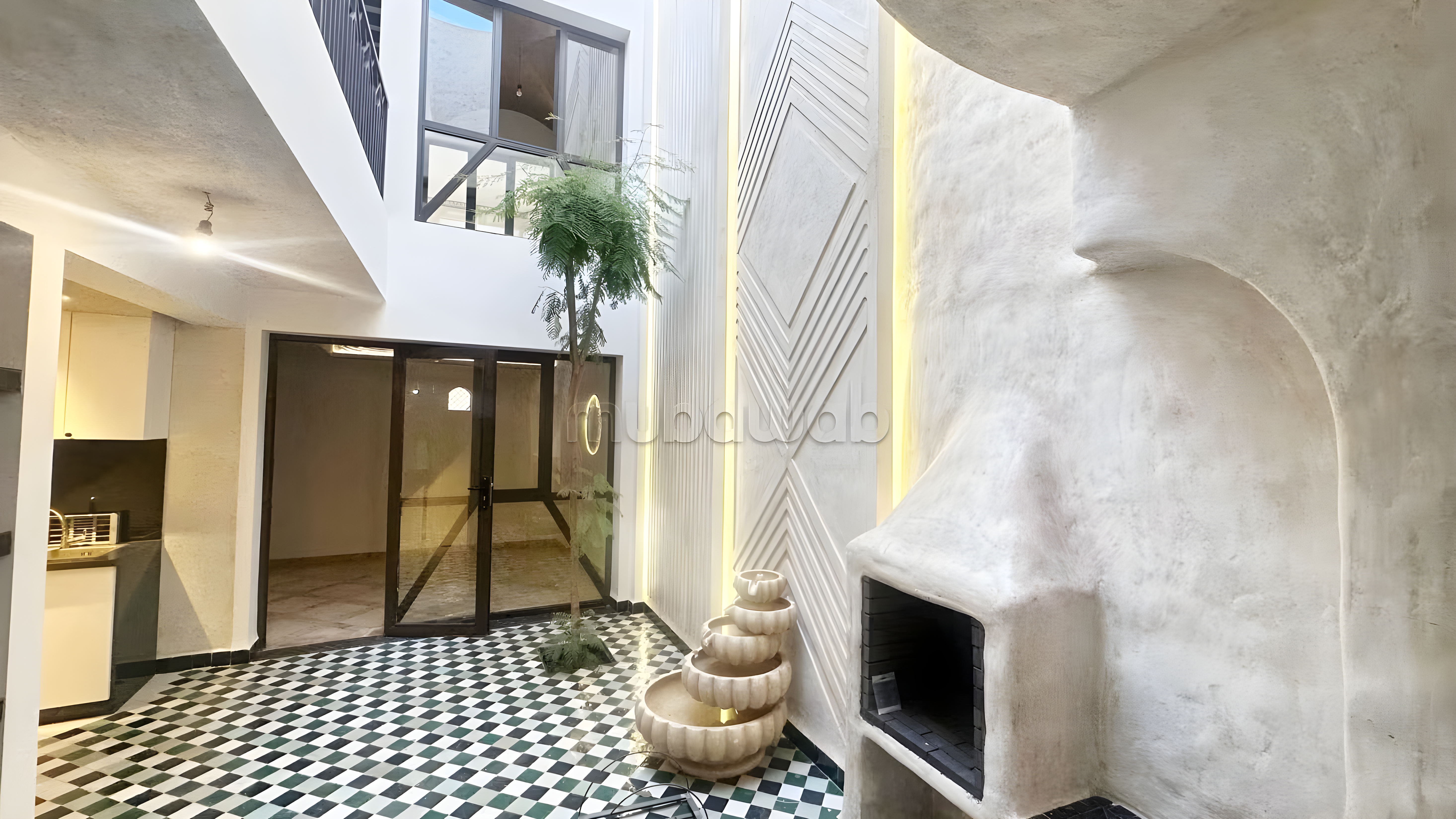 Courtyard with fireplace and black-and-white tiled flooring in Sidi Mimoun guesthouse.