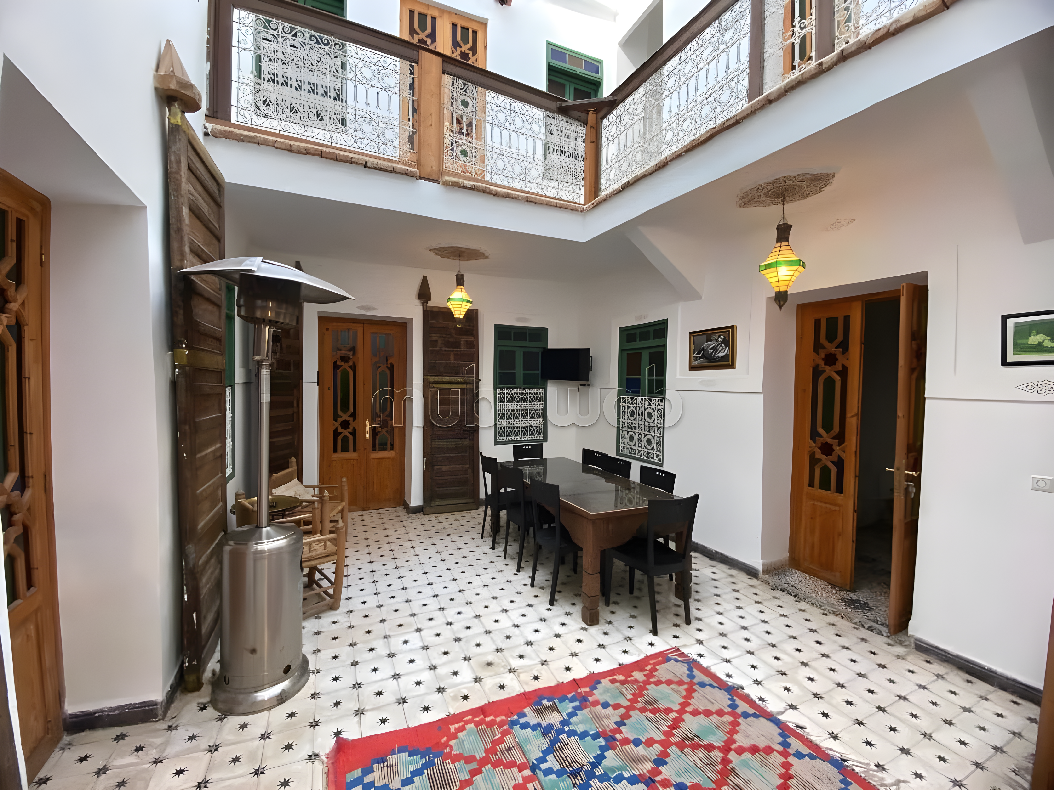 Traditional courtyard with tiled floors and dining area in Riad Zitoun guesthouse.