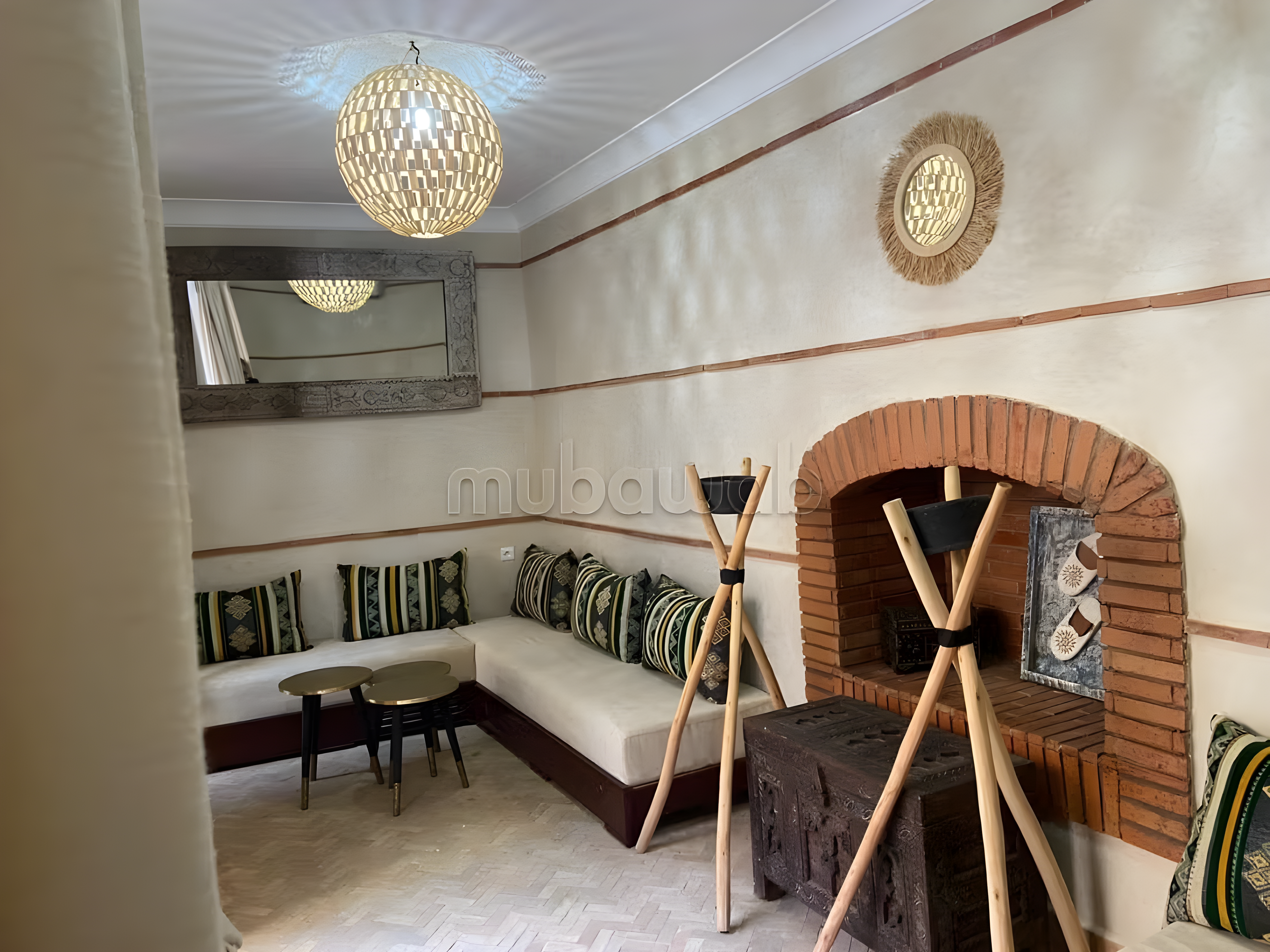Marokkanischer Salon mit eingebauten Sitzplätzen, gemusterten Kissen, Kamin und Beleuchtung.