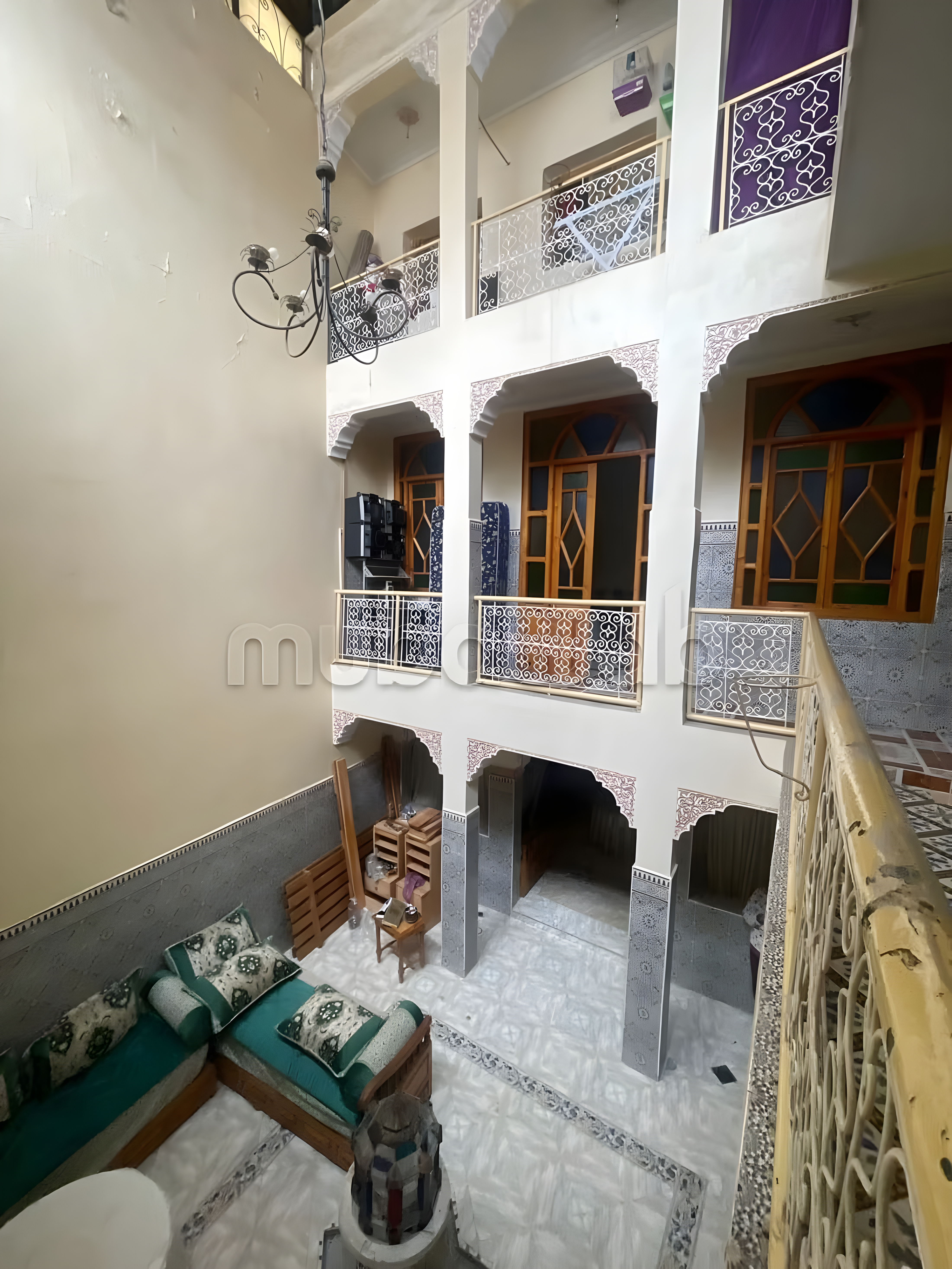 Moroccan courtyard with intricate tiles in Sidi Ben Slimane El Jazouli guesthouse.