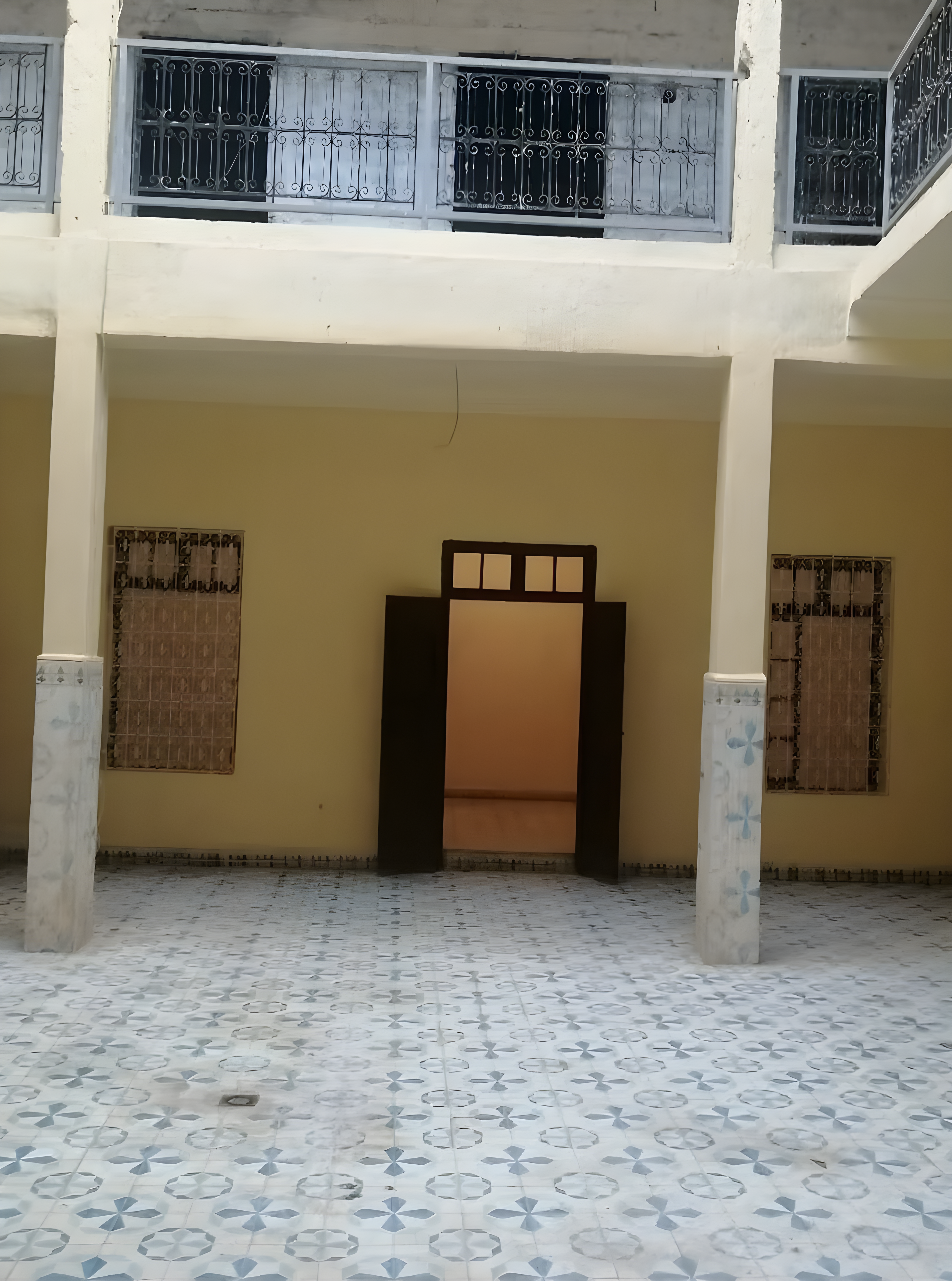 Open courtyard in a riad near Bab Ghmat with pillars and tiled floors.