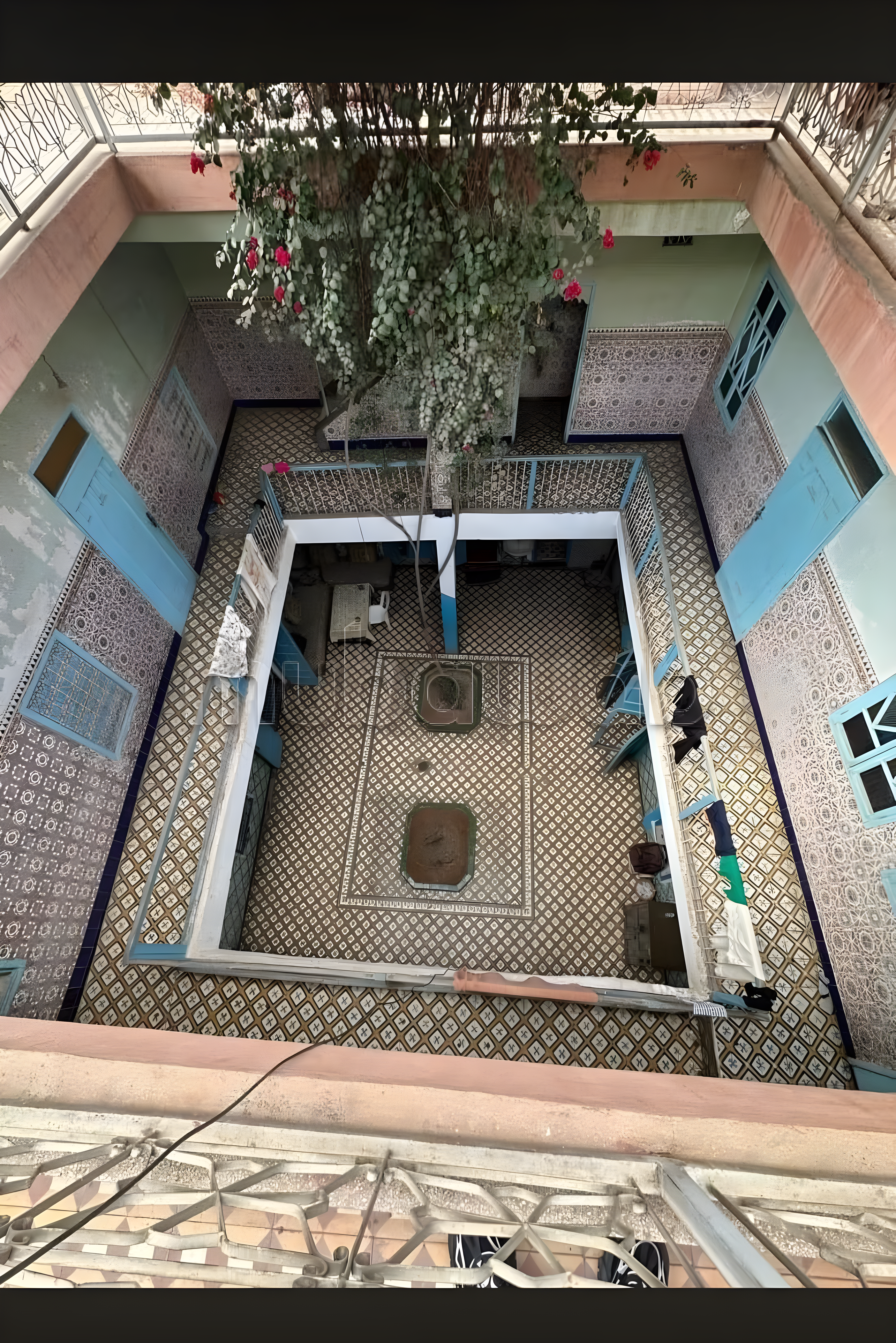 Central courtyard in Arset El Houta with tiled flooring and a hanging plant.