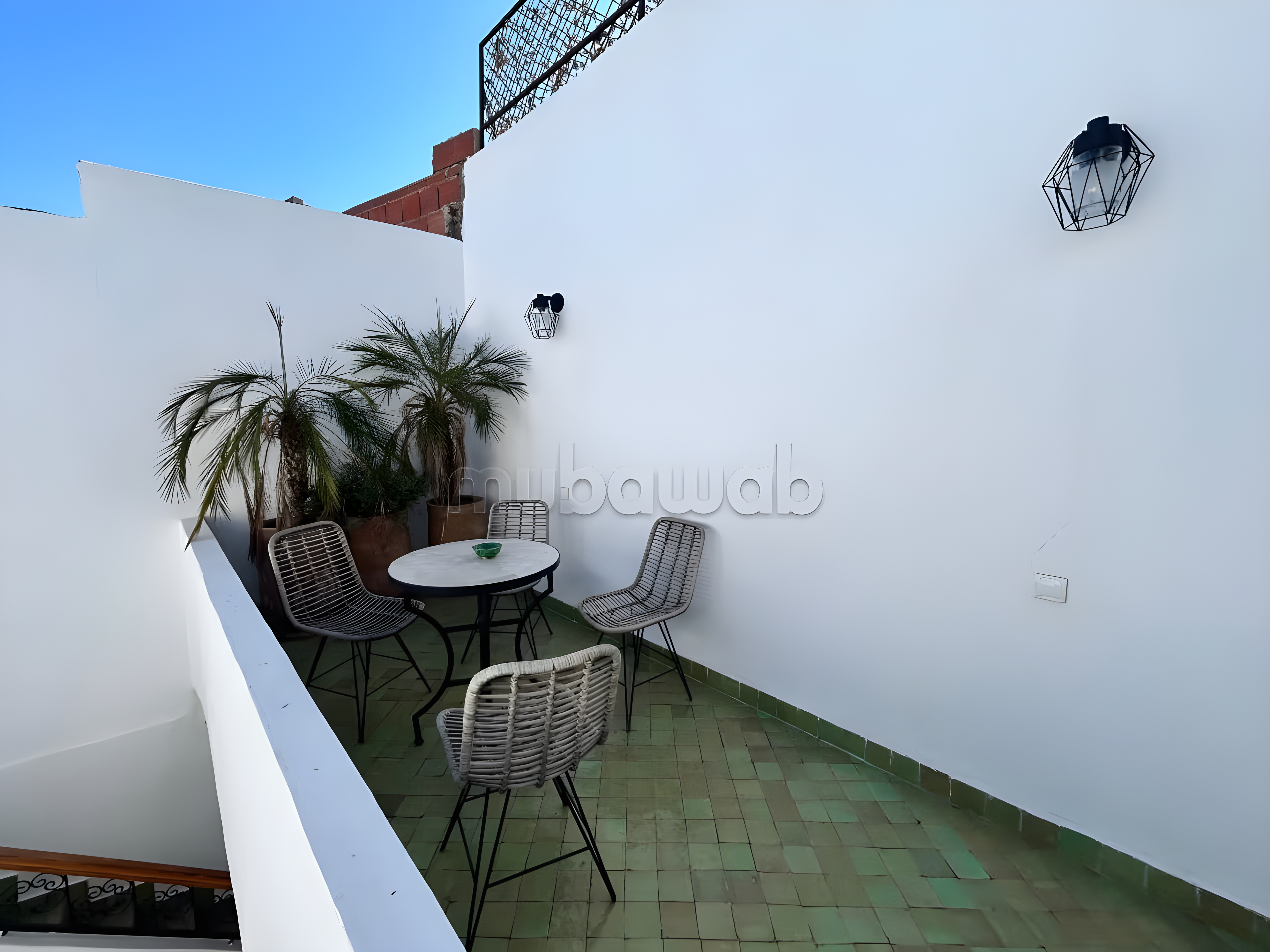 Guesthouse terrace in Assouel with green tiles and seating area.