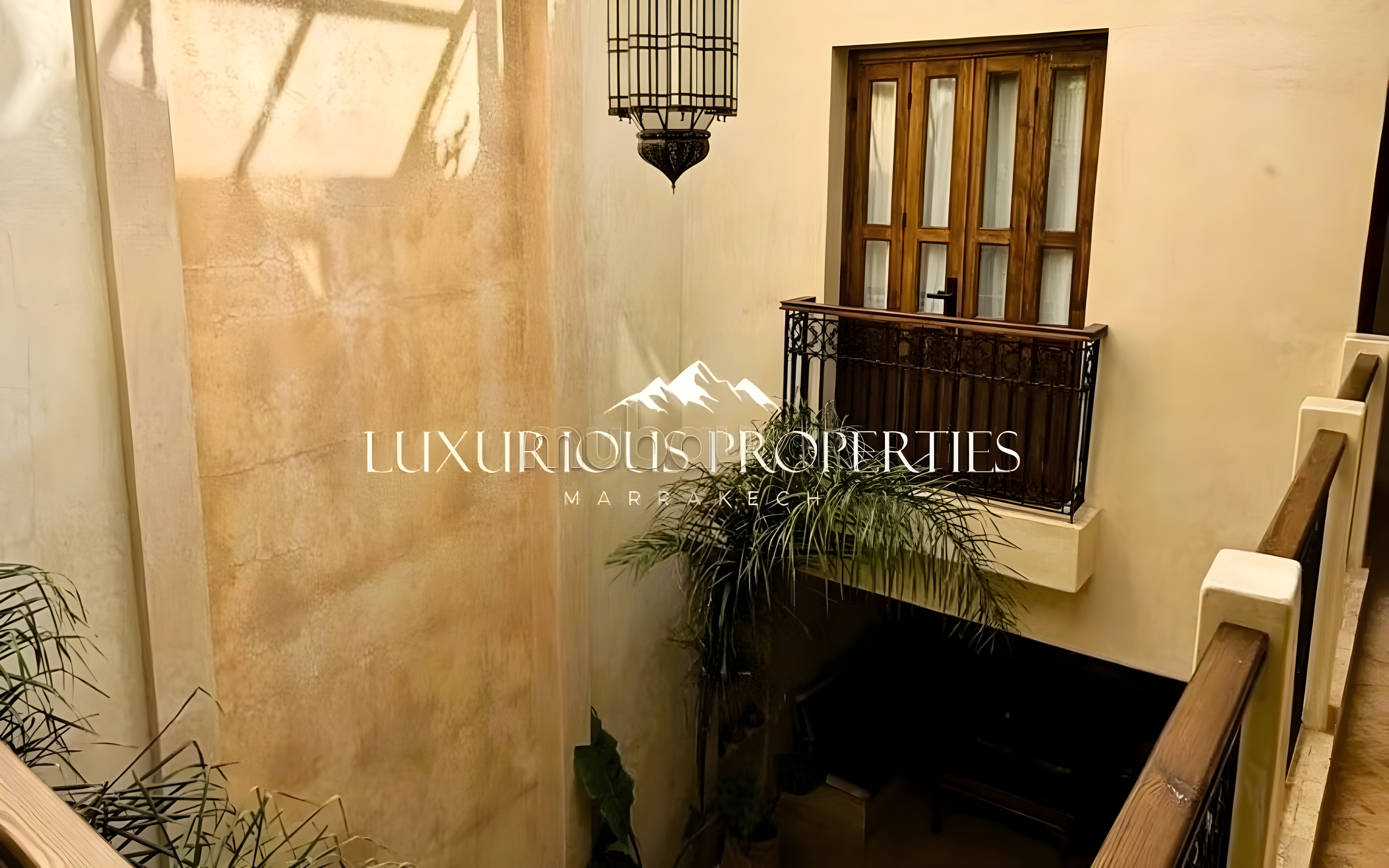 Moroccan guesthouse courtyard with plastered walls and plants in El Moukef.