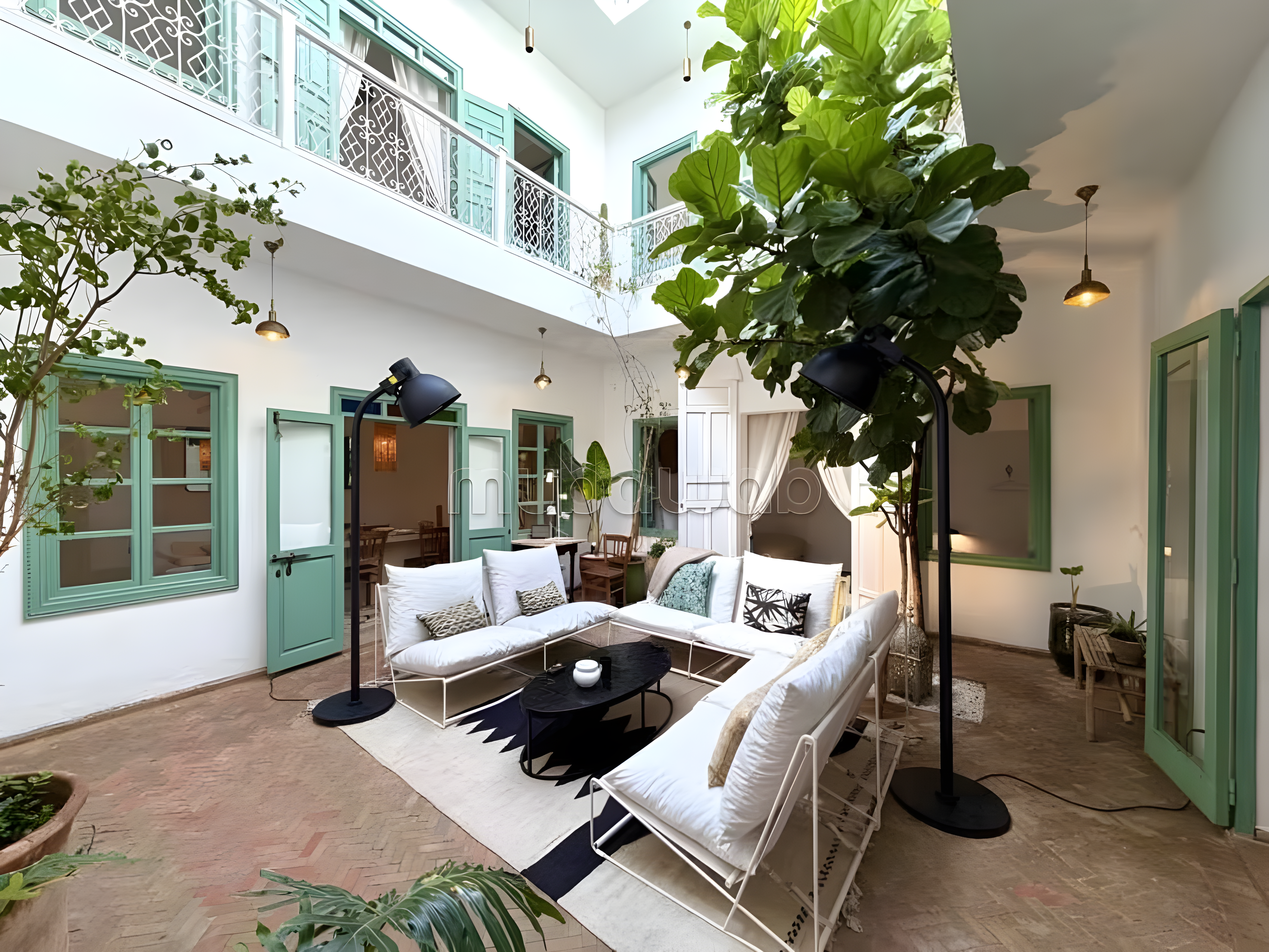 Charmant patio d'une maison d'hôtes à Assouel avec sièges élégants et plantes.